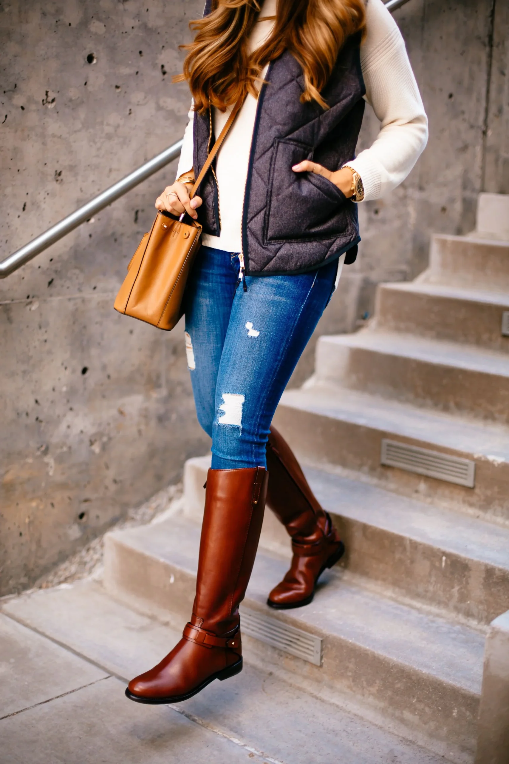 Thanksgiving outfit with quilted vest, skinny jeans, and tall riding boots