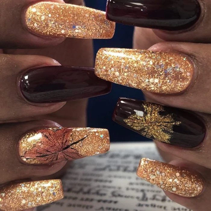 Gold glitter nails mixed with deep burgundy and leaf art