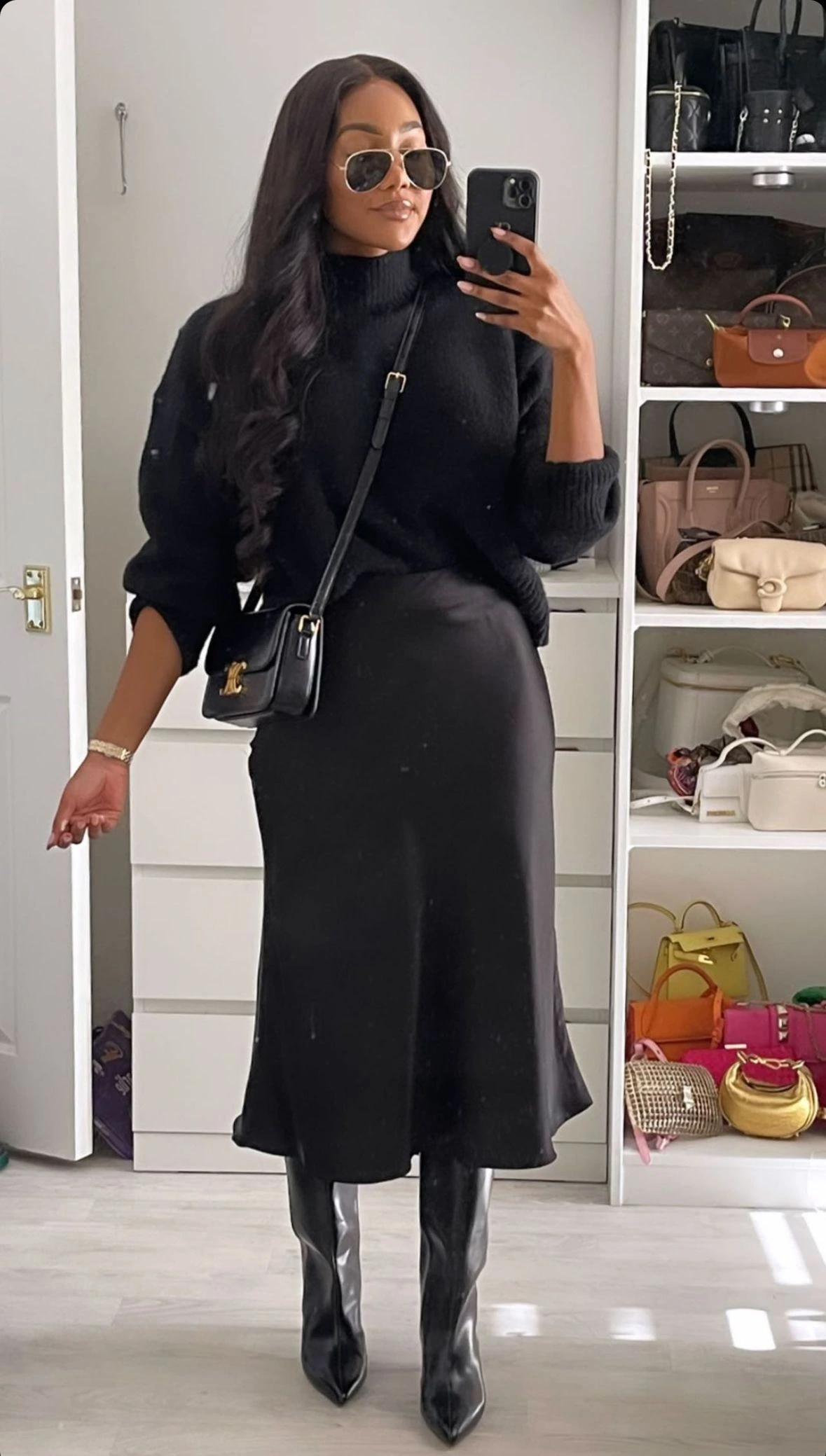 Woman in a black turtleneck with a satin midi skirt and boots