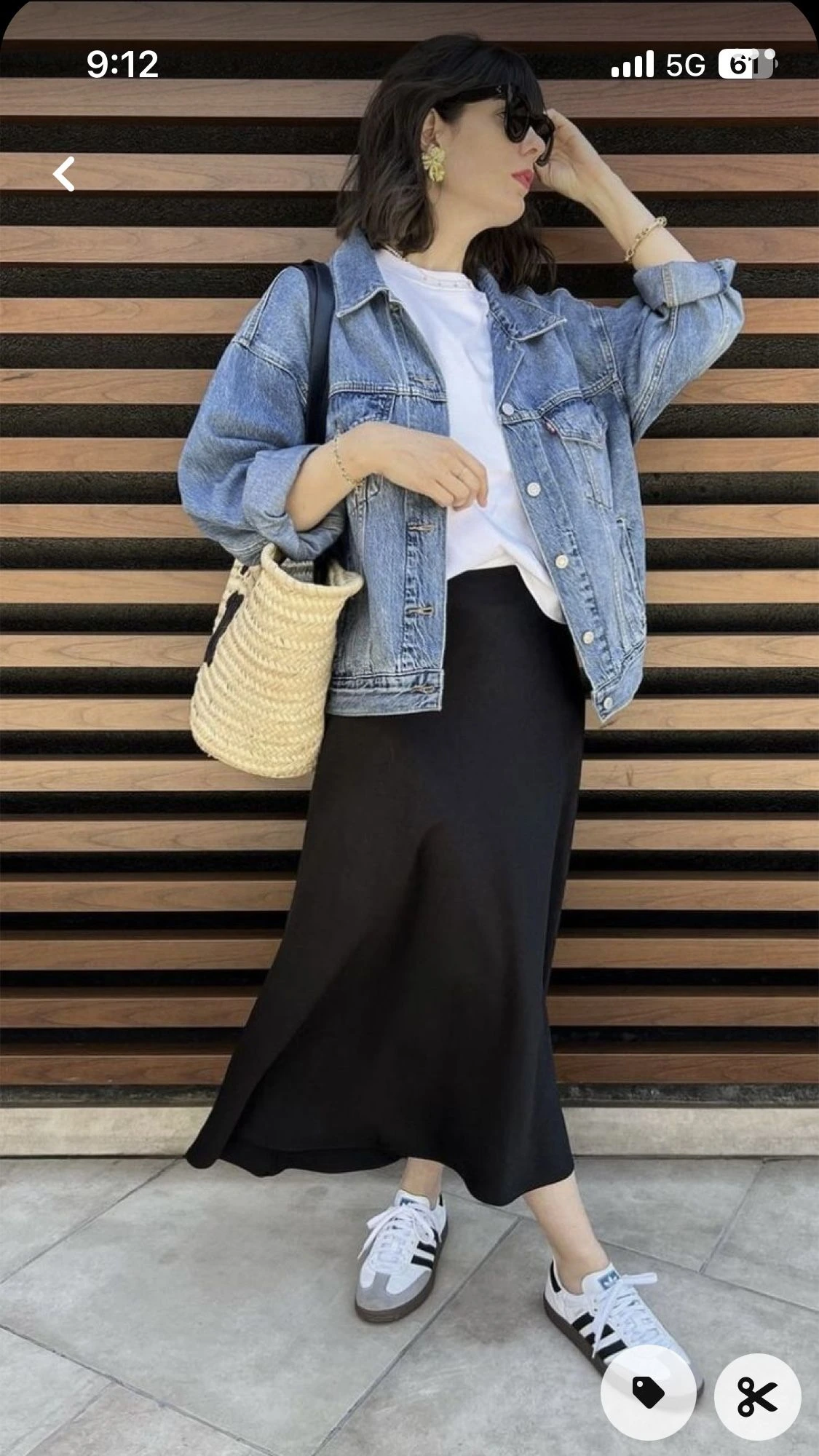Woman wearing canvas sneakers with a denim jacket and midi skirt