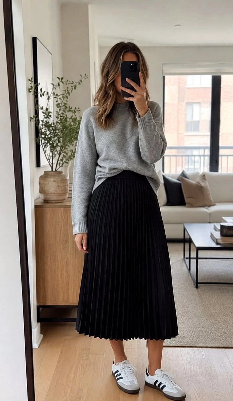 Woman wearing platform sneakers with a soft sweater and pleated midi skirt