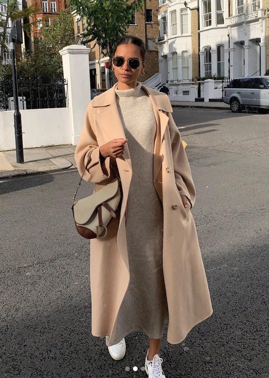 Woman wearing clean sneakers with a wool coat and knit midi dress