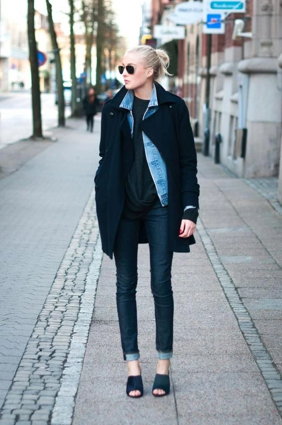 Woman layering a denim jacket under a wool coat for fall