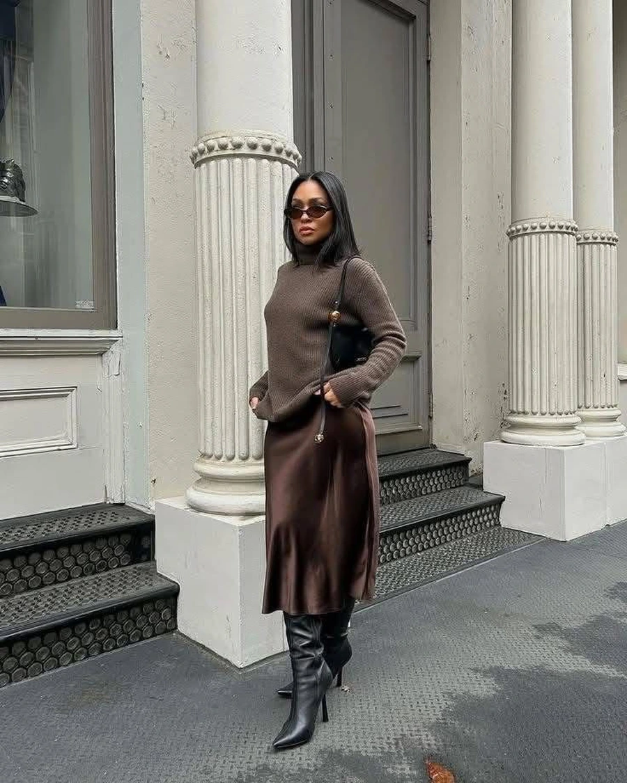 Tall woman wearing a midi skirt with boots
