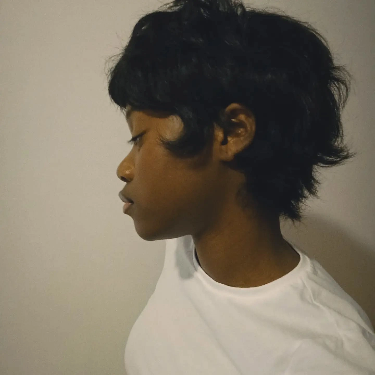 Woman with curly hair in a short spiky pixie cut