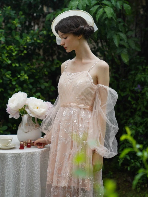 Lizzy McAlpine concert outfit: blush dress with hat in a garden