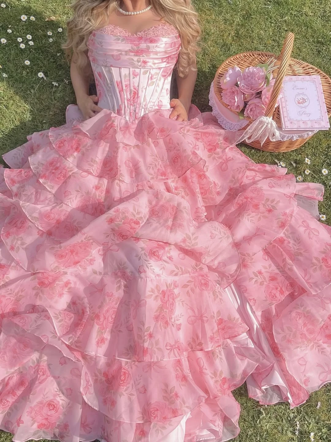 Lizzy McAlpine concert outfit: pink ruffled dress with basket on grass