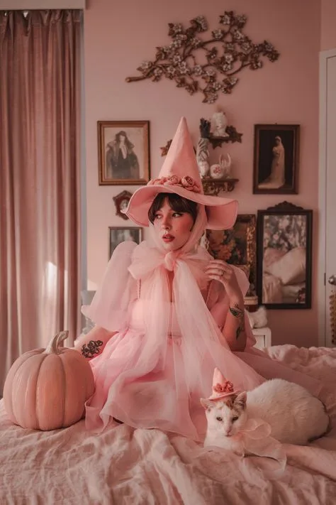 Pink hair halloween costume: pink witch sitting with pumpkin