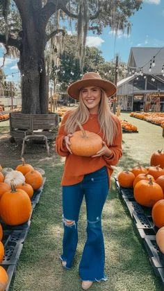 Plus size pumpkin patch outfit: rust sweater with flared jeans and felt hat