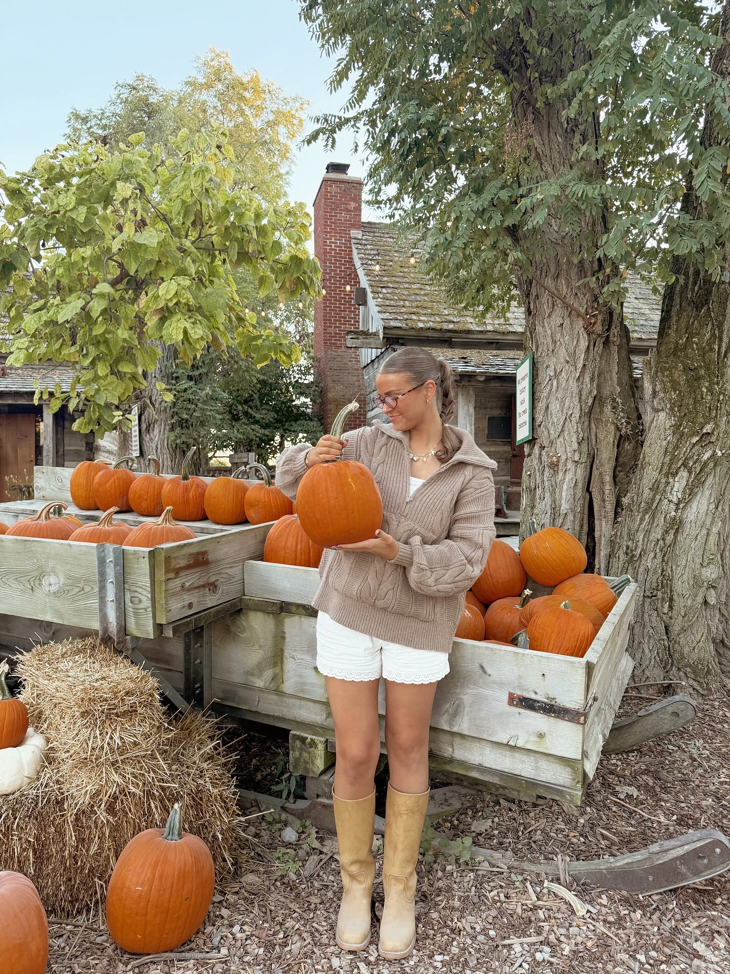 Fall pumpkin patch outfit: beige hoodie with white shorts and tan knee-high boots