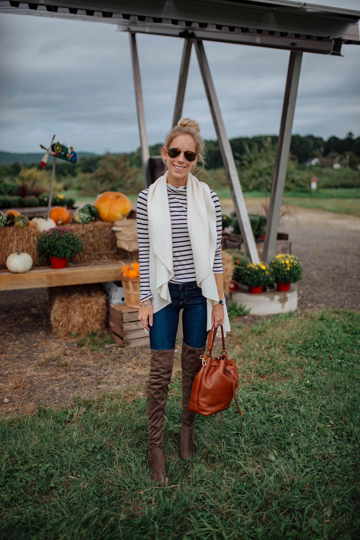 Fall pumpkin patch outfit: striped top with long white vest and over-the-knee boots