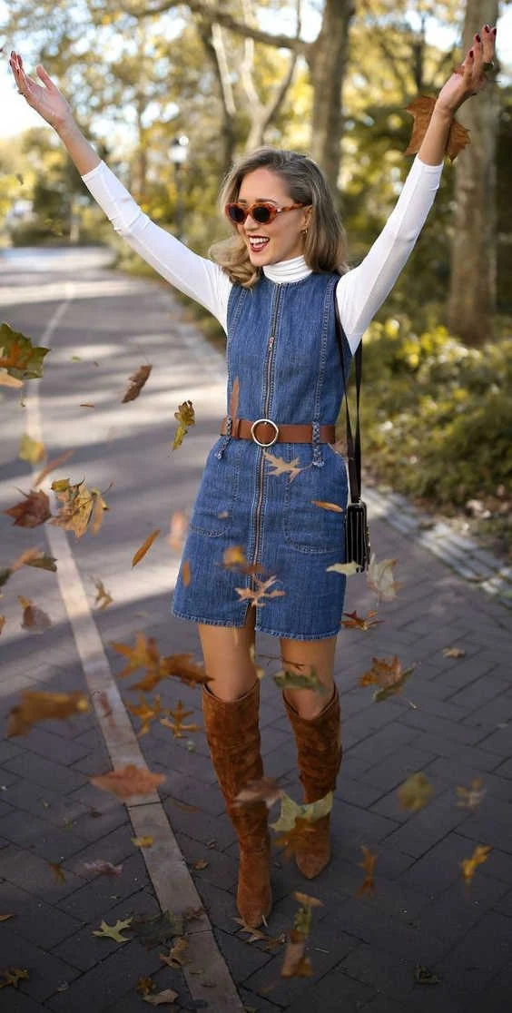 Petite woman wearing belted denim dress with brown boots for Thanksgiving