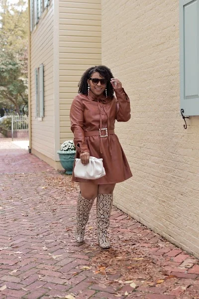 Fall outfit for black woman: rust faux leather shirt dress with snakeskin boots