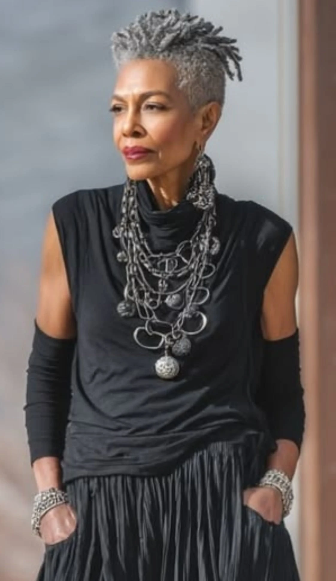 Veterans Day outfit for Black women in their 50s: black layered look with statement silver jewelry