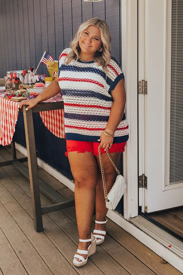 Plus size woman in striped knit top and red shorts with white wedges