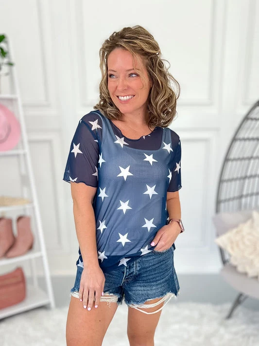 Plus size woman in blue star print mesh top and denim shorts
