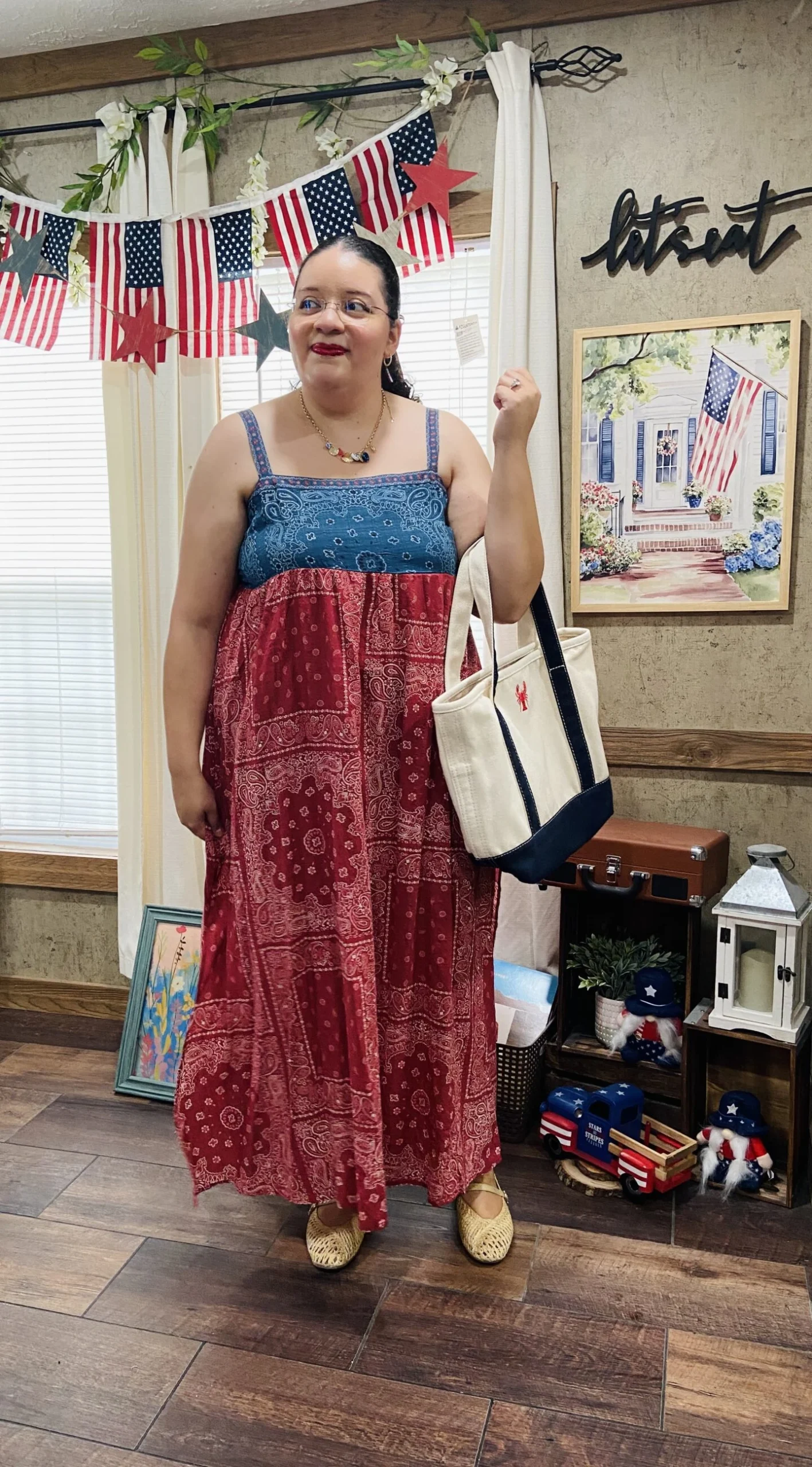 Plus size woman in red and blue bandana print maxi dress with canvas tote