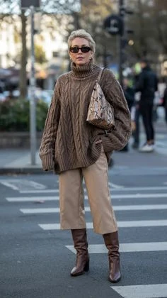 Brown cable-knit sweater with beige trousers and brown knee-high boots