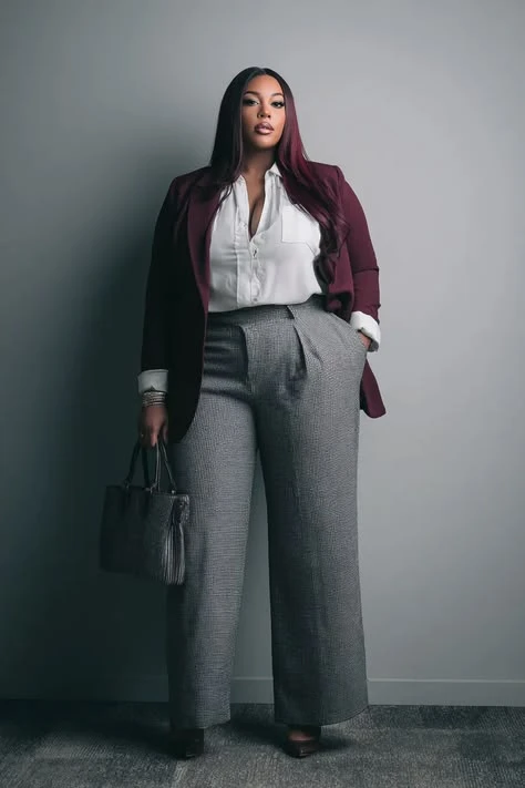 Veterans Day business casual outfit: houndstooth blazer with burgundy pleated trousers on curvy woman