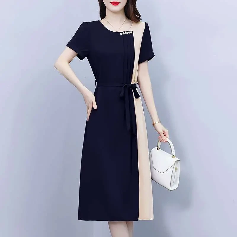 Veterans Day work outfit: Navy and beige color block short sleeve office dress with white bag