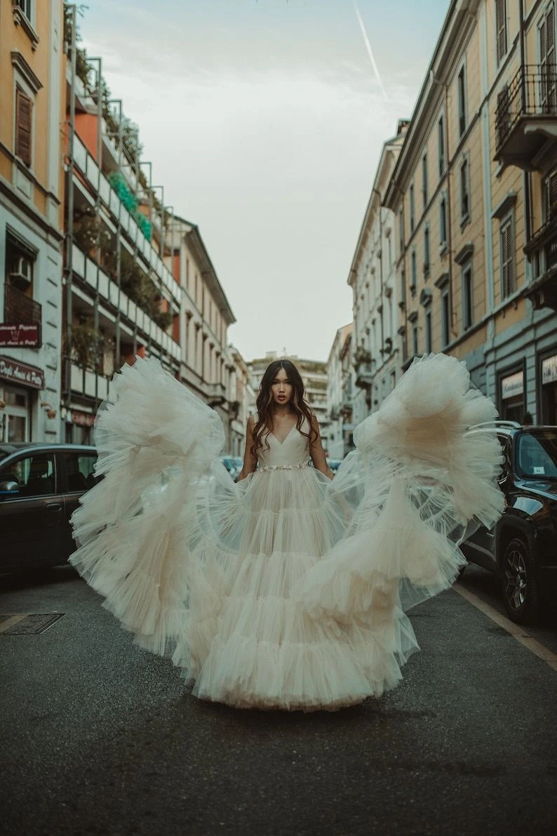 Whimsical outfit idea: white tiered tulle gown twirling on a city street