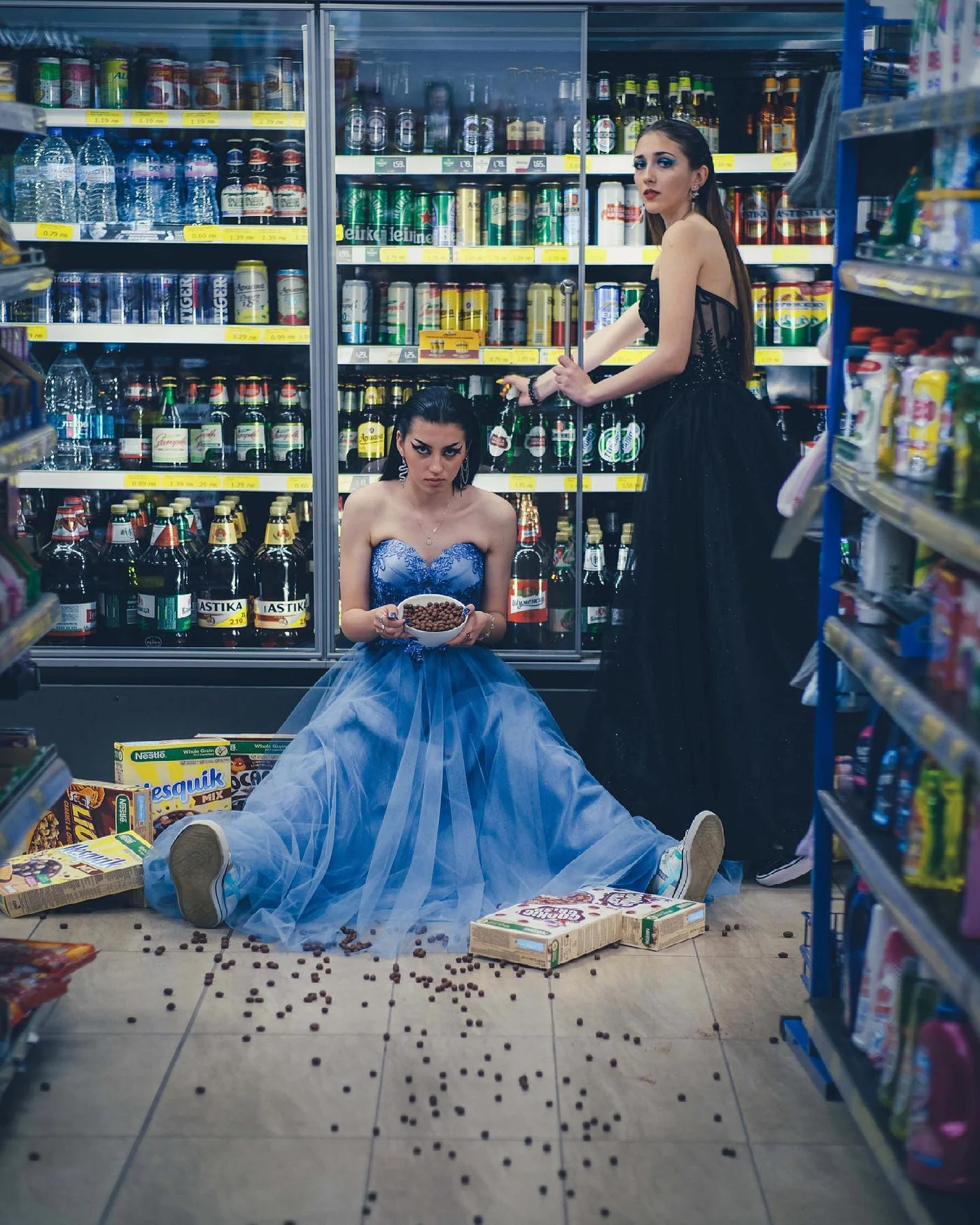 Woman in a blue ballgown sitting on the floor of a store aisle