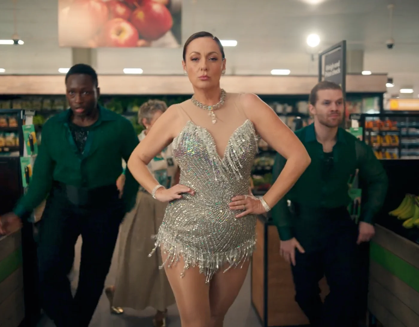Woman in a sparkly silver dress posing in a subway station