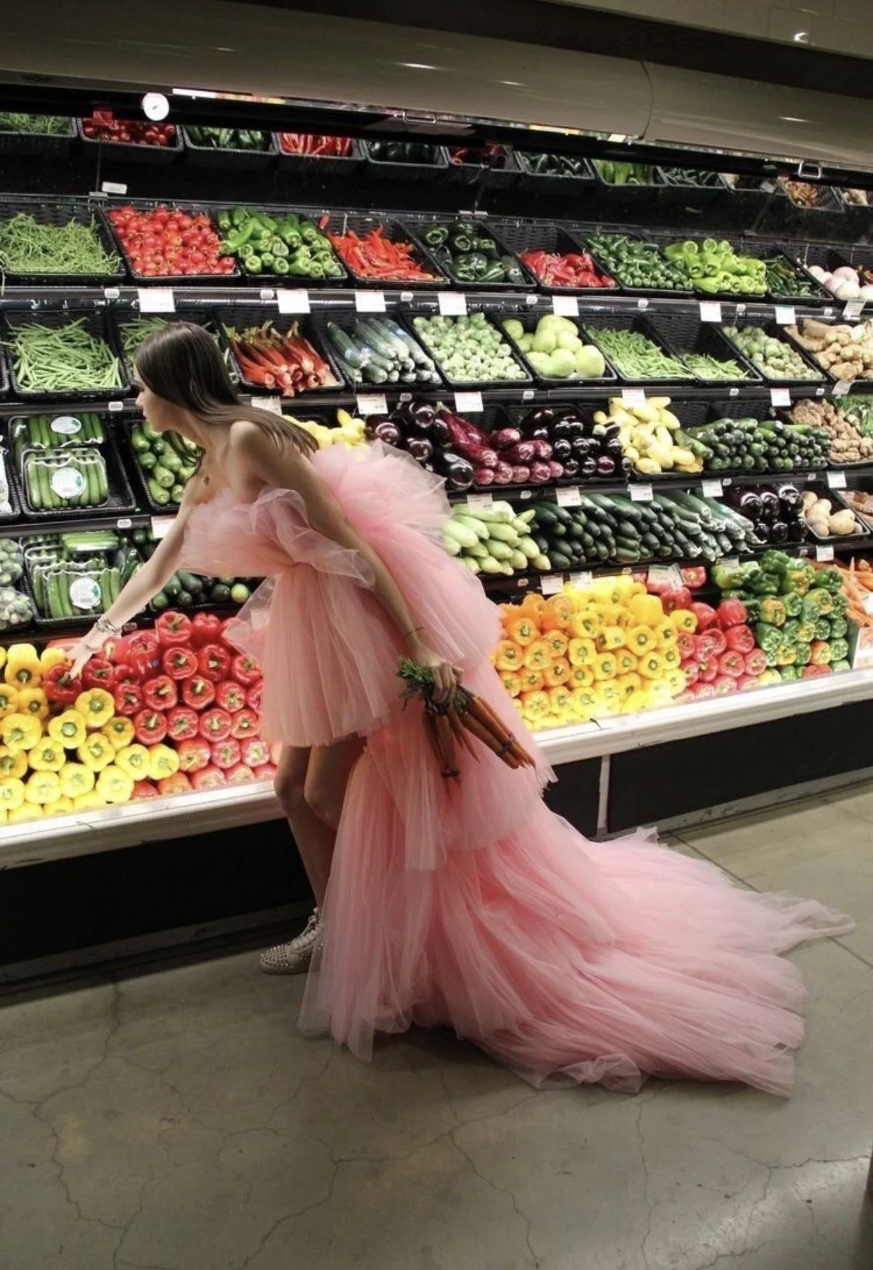 Woman in a pink ballgown shopping in the produce section