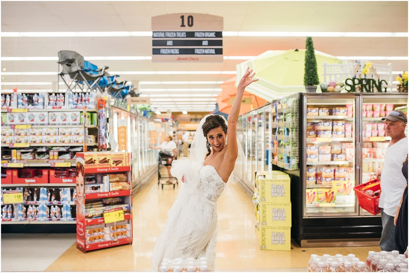 Bride dancing in a supermarket aisle in her wedding dress