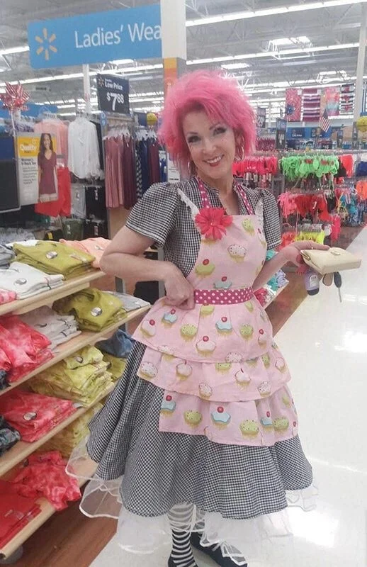 Woman with pink hair in a maid style outfit at Walmart