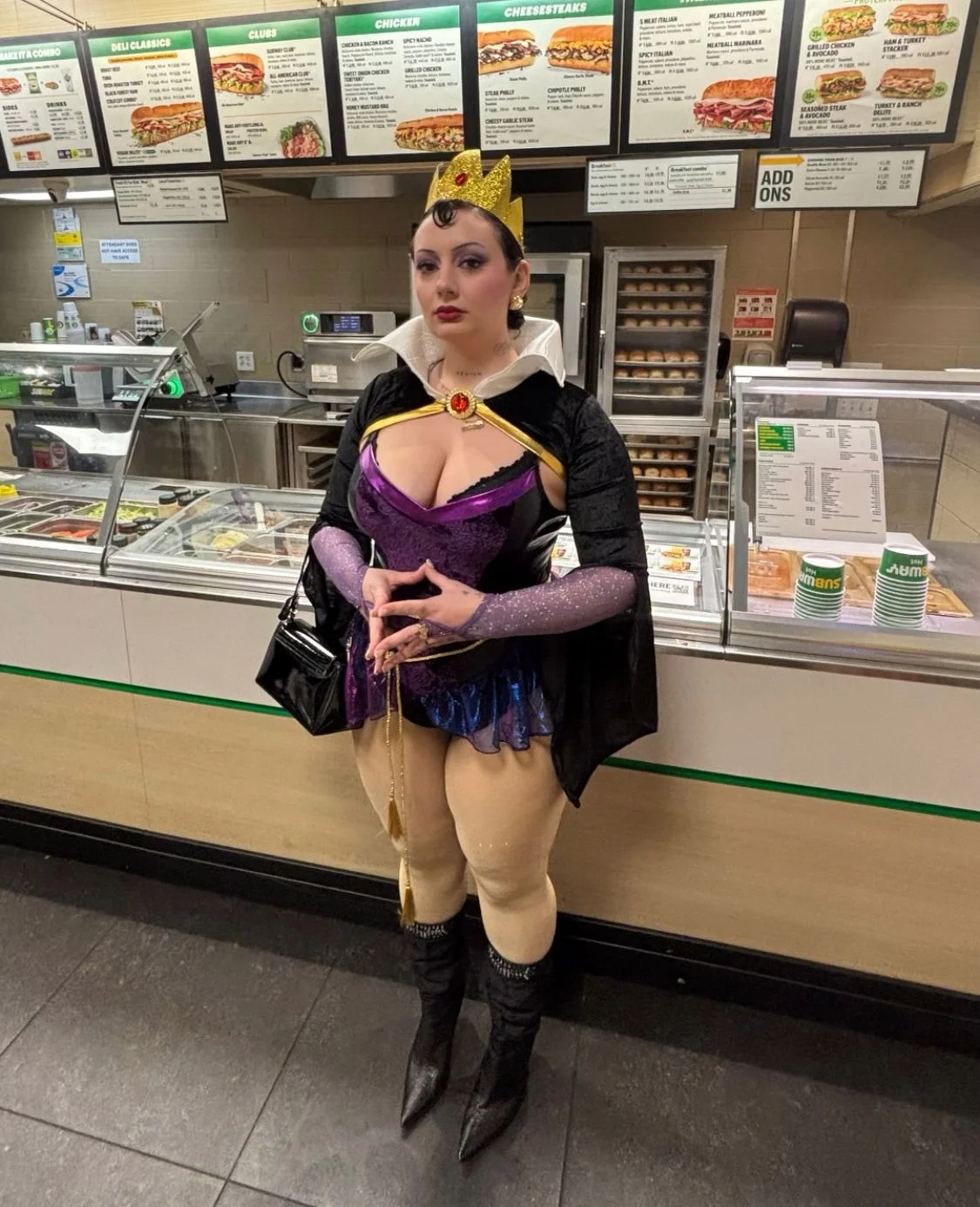 Woman in a queen costume with a crown at a food counter